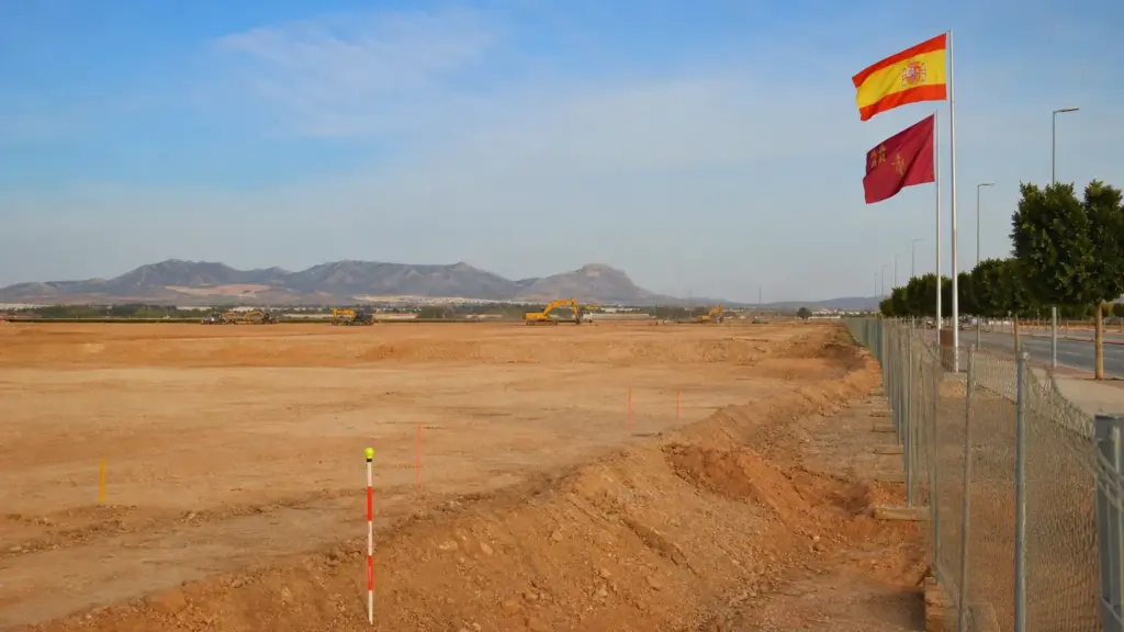 metrovacesa en murcia: terreno amplio en las afueras de la ciudad preparado para un parque comercial, con máquinas a lo lejos