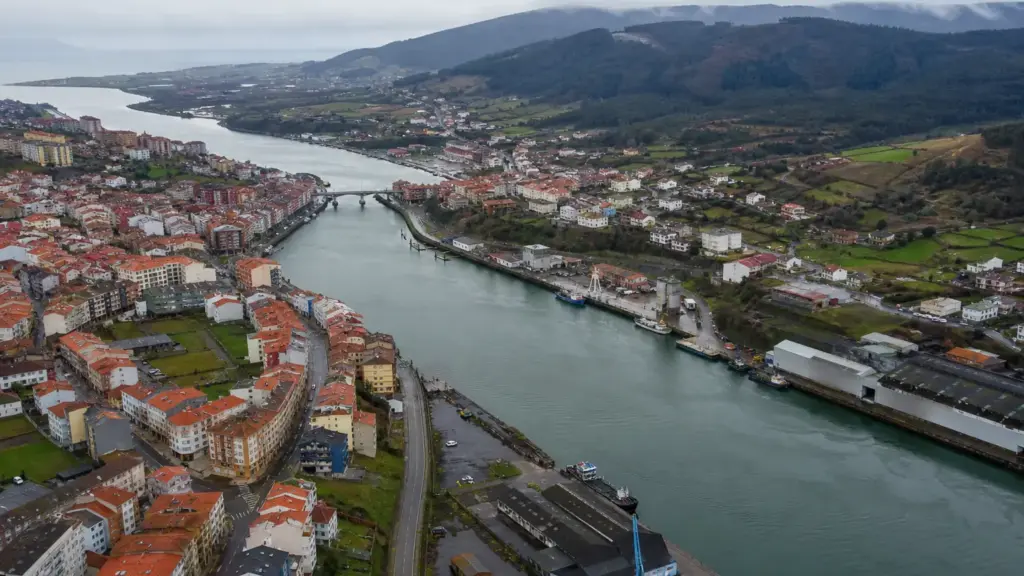 aborto en avilés: vista aérea de la ría y los tejados de una ciudad costera en una mañana nublada