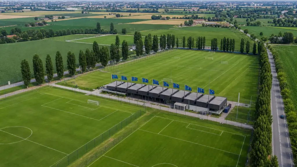 copropiedades del inter: vista aérea de campos de entrenamiento de fútbol en las afueras de Milán con banderas azules y negras