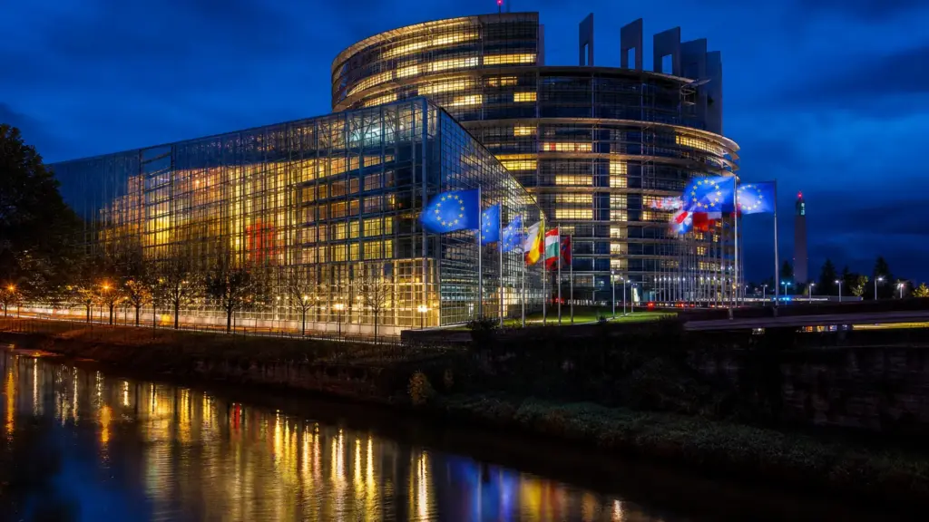 día contra la homofobia: edificio del Parlamento Europeo iluminado de noche con banderas de la Unión Europea