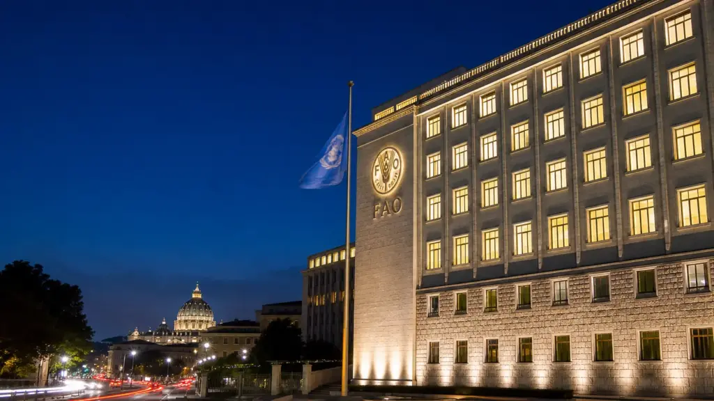 centro de crisis fao: sede de la FAO en Roma iluminada de noche con la bandera de la ONU