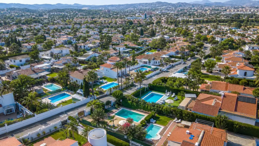 ahogamientos de niños: vista aérea de un barrio con piscinas privadas rodeadas de vallas de seguridad en verano