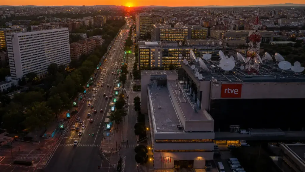 ingresos de atresmedia: vista aérea de una avenida con vallas publicitarias y antenas de televisión al atardecer