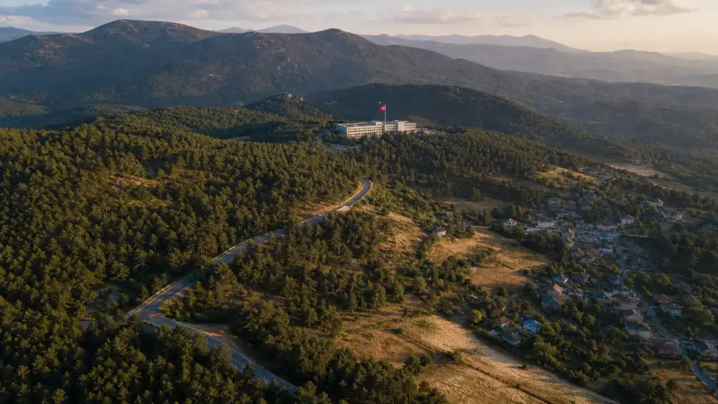 gobierno de ayuso: vista aérea de la sierra oeste madrileña con bosques, pueblos y una bandera de la Comunidad de Madrid
