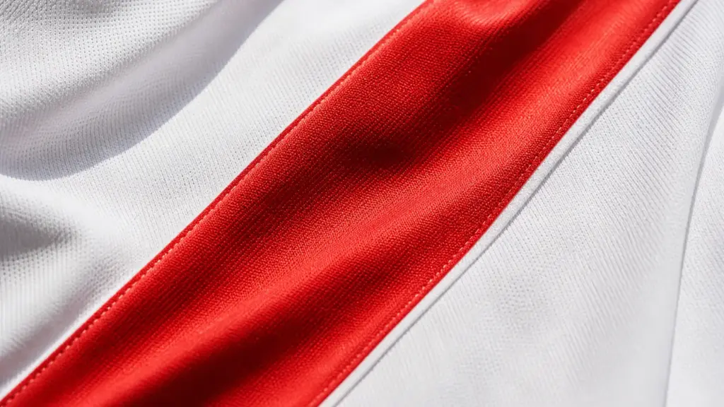 afición del rayo vallecano: detalle de una camiseta blanca de fútbol cruzada por una franja roja