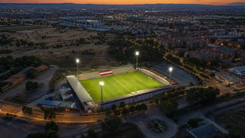 sporting de hortaleza: vista aérea de un estadio municipal iluminado al anochecer en Alcalá de Henares