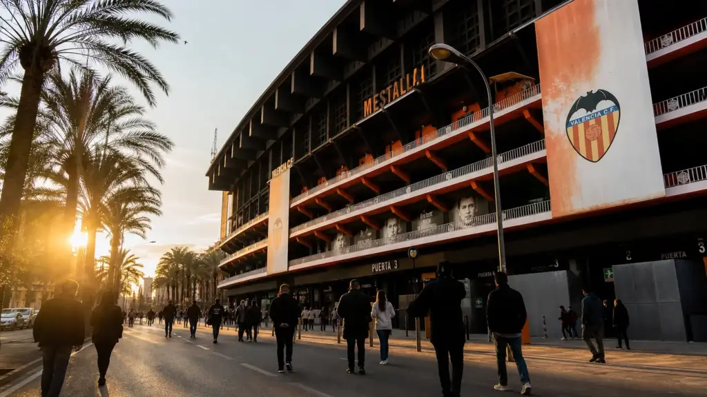 pachu martínez: exterior del estadio de Mestalla con aficionados lejanos caminando al atardecer
