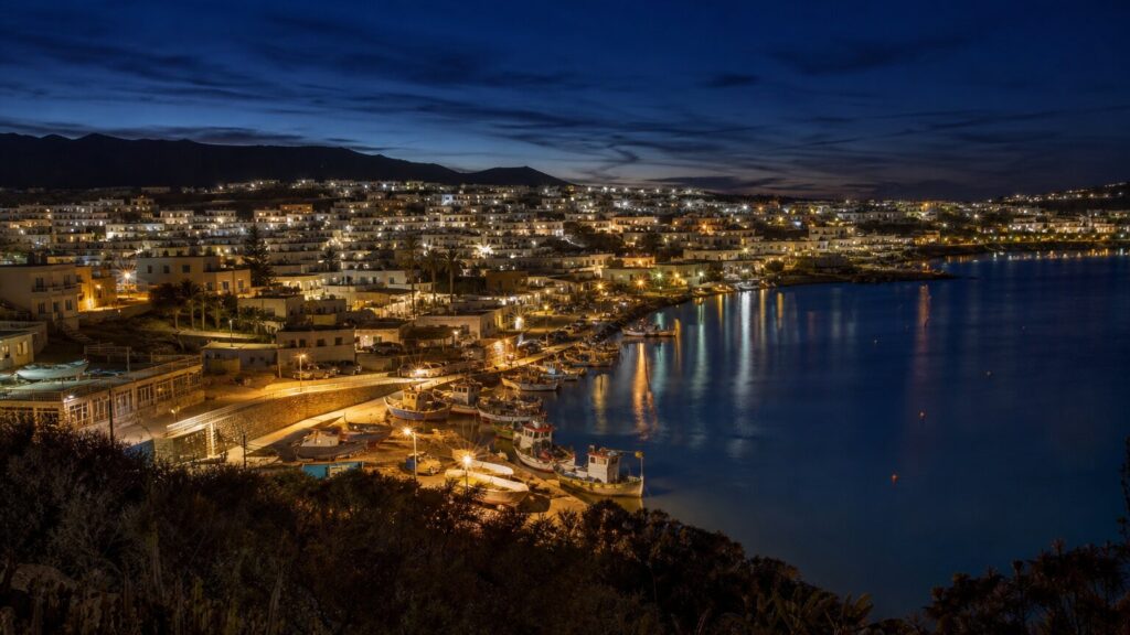felipe vi en ceuta: puerto costero de noche con luces cálidas reflejadas en el agua y ventanas iluminadas