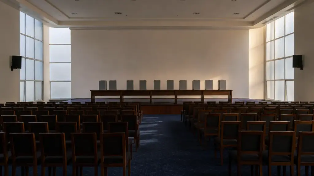 ley de nietos: sala de conferencias vacía con urnas grises sobre una mesa larga