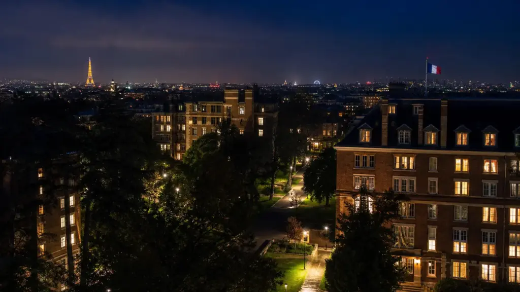 infanta sofía en parís: residencias universitarias con ventanas iluminadas de noche y la torre Eiffel al fondo