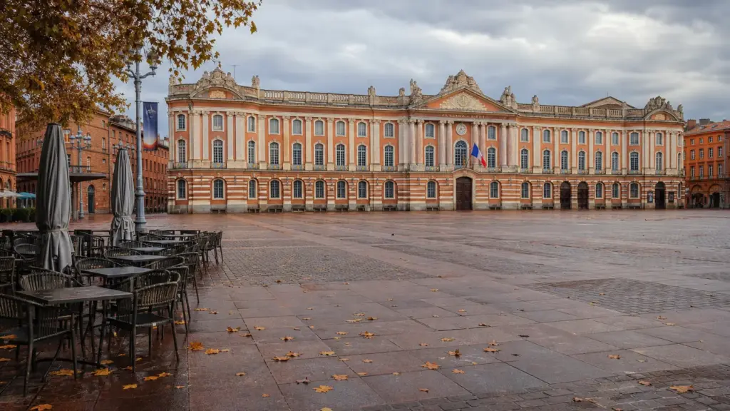 vacaciones de la toussaint: plaza del Capitolio de Toulouse con terrazas vacías bajo un cielo otoñal nublado