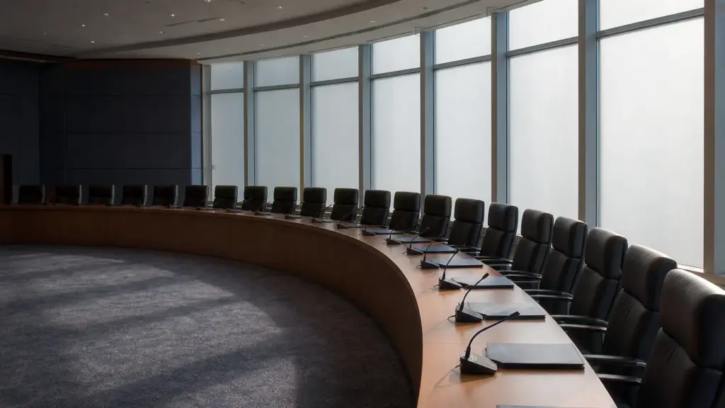 presupuesto de la ue: sala de conferencias vacía con una larga mesa de madera y sillas a la luz de la mañana