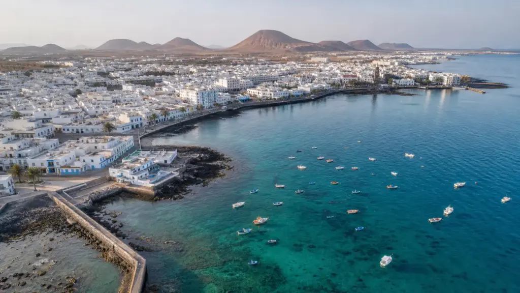 cristina calero: vista aérea de la costa de Arrecife, en Lanzarote, con casas blancas y roca volcánica junto al mar
