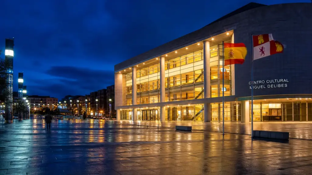 obra sobre Lorca: fachada iluminada de un centro cultural de Valladolid de noche con banderas de España y Castilla y León
