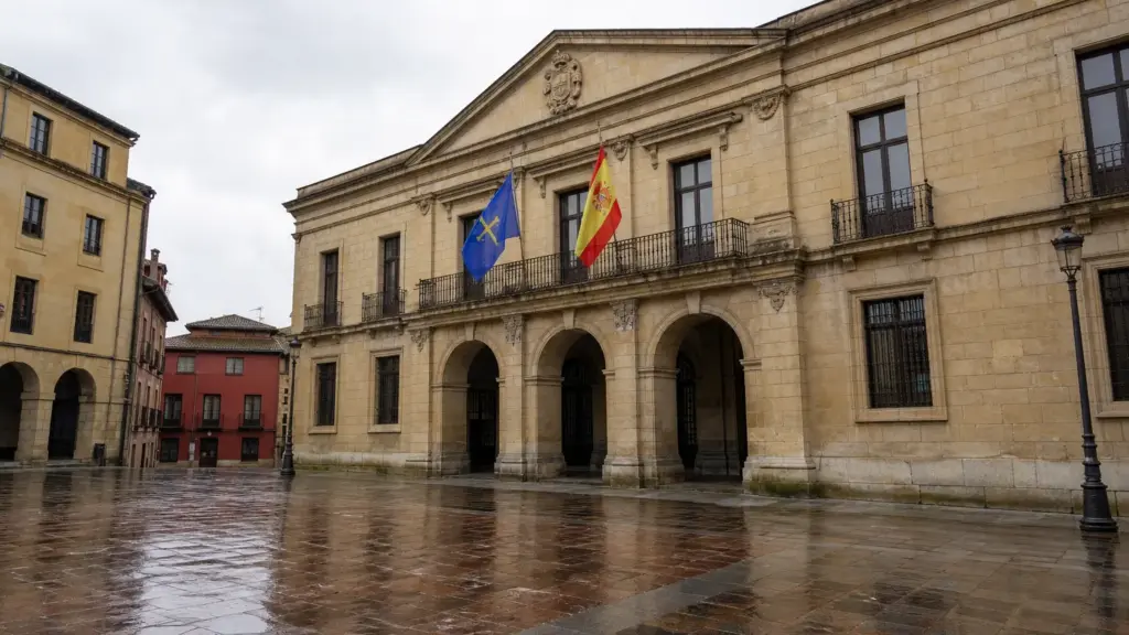 salario social básico: fachada de un edificio judicial en Oviedo con las banderas de Asturias y de España en una mañana nublada